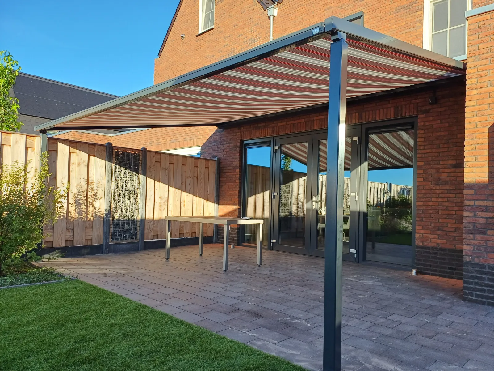 Terrasoverkapping met gestreept doek boven een terras